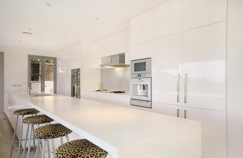 A modern kitchen design with stainless steel appliance and sparkling white benchtop.